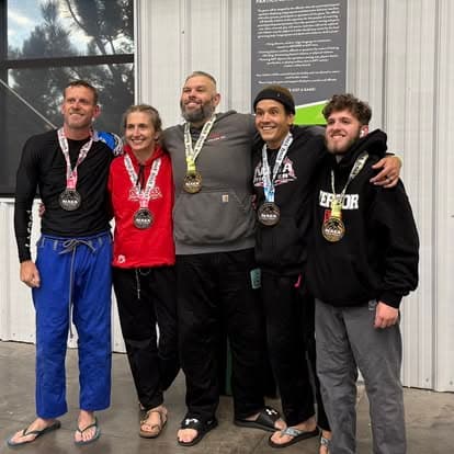 Four Imperial team members in gis holding tournament medals
