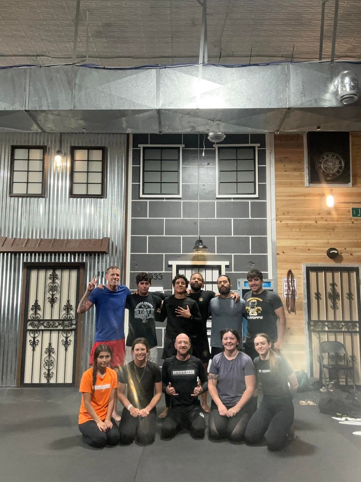 Imperial South team members photographed in front of a NAGA grappling tournament banner